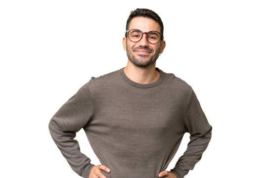 Young Handsome Caucasian Man Over Isolated Background Posing With Arms At Hip And Smiling