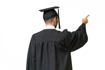 Young university graduate man over isolated background pointing back with the index finger