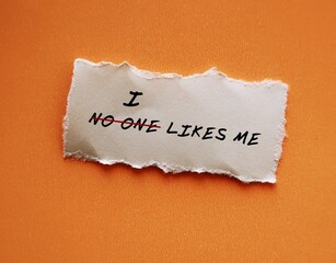 Torn paper on texture background with handwritten text NO ONE LIKES ME change to I LIKE ME concept...