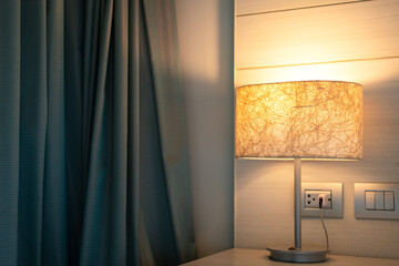 A modern-luxury design lighting lamp which is glowing in orange warm light shade. Interior...