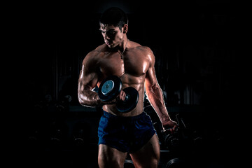Fototapeta na wymiar Bodybuilder posing on black background. Muscular and athletic young man doing bodybuilding posing. Gym motivation. Bodybuilder man.