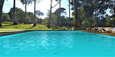 Eye-catching waves on the surface of turquoise water in an amazing pool in the recreation area of a club country estate located in a tropical forest. 3d rendering.