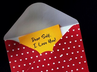 Red heart envelope with handwritten card DEAR SELF, I LOVE YOU - concept of single person writing...