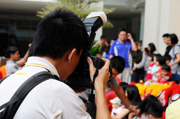 MELAKA, MALAYSIA -MARCH 5, 2020: Photographer is using a camera to take pictures of an event. A digital camera is used and adjusted according to the desired angle to get a good picture.
