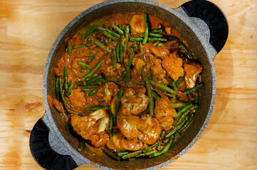 Baked green beans, chicken meat,, mushrooms, lemon and sesame seeds mixed in blue bowl. Healthy and balanced meal