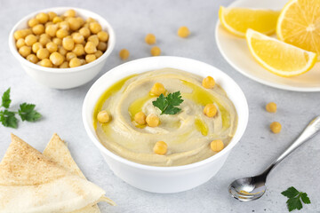Chickpea hummus with pita, olive oil, parsley and lemon on a gray background. Arabic, Turkish...