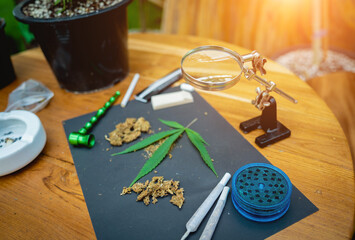 Joints and buds of medical cannabis and cigarettes on a wooden table