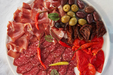different types of sausages and ham sliced and beautifully arranged on a plate