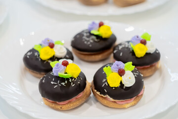 Close up: assortment of delicious fresh shortcrust tart cakes with cream and chocolate on white plate for sale at restaurant, cafe, bakery. Dessert, culinary, sweet food and confectionery concept