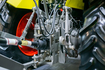 Back view of modern yellow tractor machine at agricultural trade show, market, exhibition