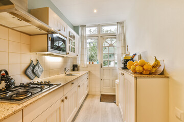 a kitchen with some fruit on the counter and an open window in the back wall to the room is white