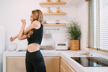 happy woman stretching improve arms movement. smiling pretty woman warming before or after exercising reduce muscle tension. beautiful woman training home fitness trying twisting arms for stretching