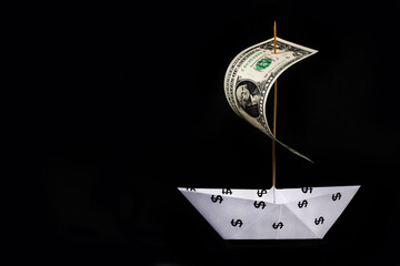 Paper boat with the symbol of the American dollar and a sail made of a bill of 1 dollar