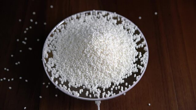 Close-up of plastic polymer granules, hand hold Polymer pellet, polymer plastic, compound polymer, Technology product of plastic chemical, green polymer, resin from petrochemical,