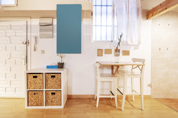 Kitchen of a coworking office with a red countertop and white cabinets, stainless steel stools with black upholstered seats and a bay window in the background