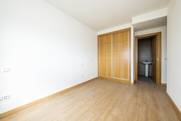 bedroom with a two-section built-in wardrobe with sliding oak doors and wood-like stoneware floors...