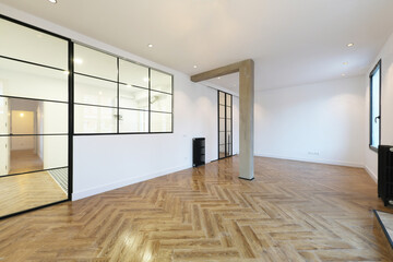 Obraz premium Loft-style apartment with wood-like stoneware floors with glass and metal partitions and black cast iron radiators