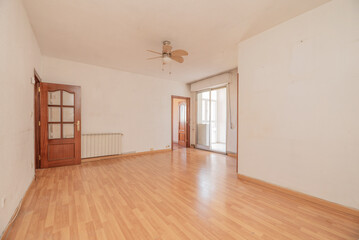 Empty living room with sapele wood interior doors with windows and a closed terrace with aluminum and glass doors