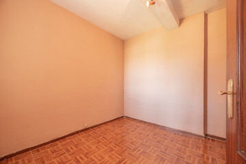 Empty living room with sapele wood interior doors with peach painted walls and parquet wood-like stoneware floors