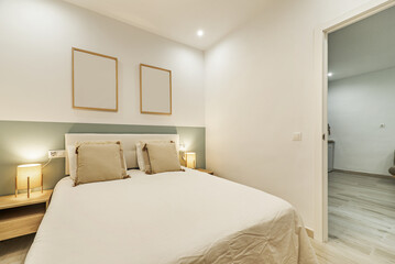 Bedroom with double bed with upholstered headboard and fiber lamps