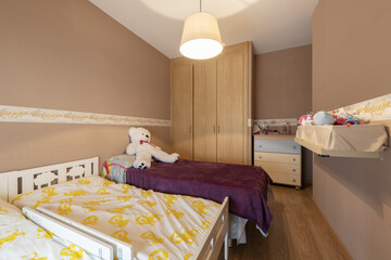 Youth bedroom with small beds and baby paraphernalia