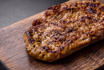 Delicious juicy grilled pork steak with spices and herbs