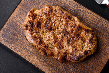 Delicious juicy grilled pork steak with spices and herbs