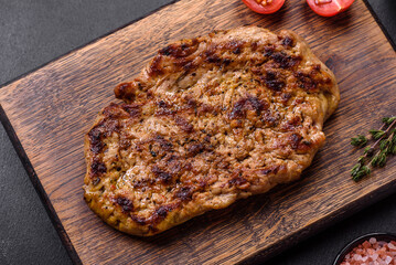 Delicious juicy grilled pork steak with spices and herbs