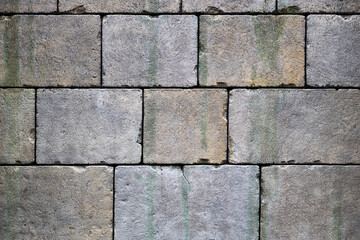 large large gray stones in the wall, the wall of large stones is assembled according to the old technology