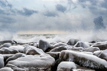 Winter storm waves crash on ice covered rocks.  Shot on Kew Beach in Toronto's iconic Beaches...