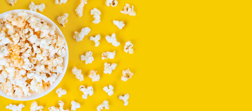 Scattered Tasty Cheese Popcorn In Bowl Isolated On Yellow Background. Wallpaper, Banner, Header With Copy Space For Text