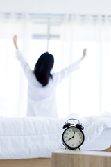 Alarm clock that is going to ring a in morning on background of woman in bed.  Alarm clock  a good...