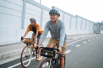 A young couple riding their bikes together in the city.