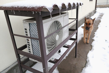 Air conditioner Outdoor Unit in Winter. The outdoor unit of the air conditioner (air-to-air heat pump) in the snow during winter operation.