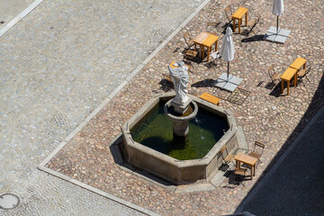 Aerial view of the cafe tables around the fountain on the square, sunny summer day