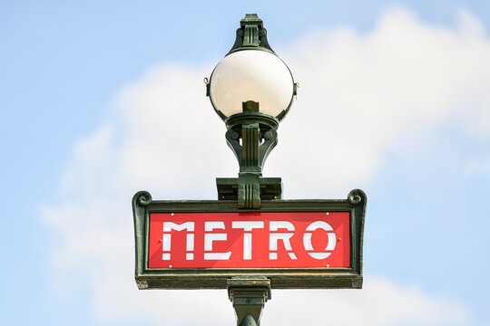 Illustration picture shows a sign with the subway logo (red symbol) in front of a parisian metro (metropolitain) station with a blue sky in the background during a summer day in Paris, France.