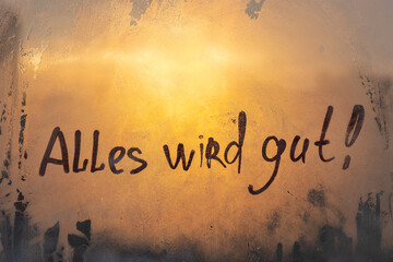 German language message Alles wird gut Everything will be fine in english are painted on wet orange...