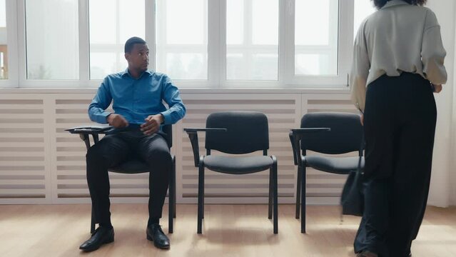 Nervous man and woman waiting for bank loan interview, feeling anxiety, queue