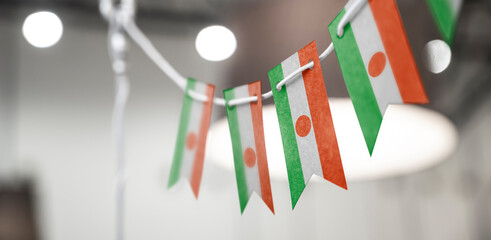 A garland of Niger national flags on an abstract blurred background