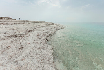 Fototapeta na wymiar Dead Sea coast and dry salt along the water
