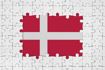 Denmark flag in frame of white puzzle pieces with missing central parts