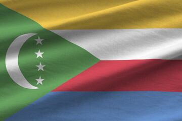 Comoros flag with big folds waving close up under the studio light indoors. The official symbols...