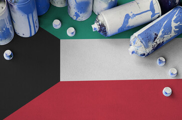 Kuwait flag and few used aerosol spray cans for graffiti painting. Street art culture concept,...