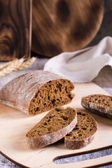 Sliced rye ciabatta on a cutting board on the table. Homemade baking. Vertical view