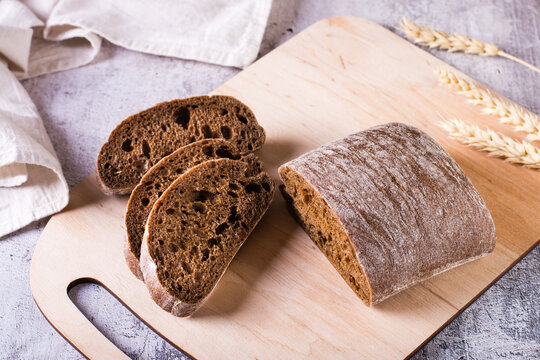 Italian Rye Ciabatta Bread Sliced On A Wooden Board On The Table.