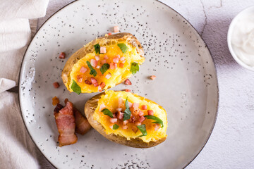 Twice baked potatoes with bacon and cheese on a plate. Homemade dinner. Top view. Closeup