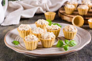 Tartlets with canned fish salad, eggs and mayonnaise on a plate. Homemade snacks