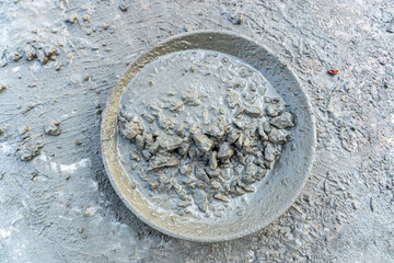 Manual mixing cement, water, sand and broken bricks.