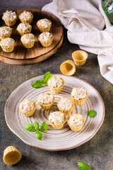 Mini tartlets with a salad of eggs, canned fish and mayonnaise. Homemade snacks. Vertical view