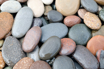 Smooth round wet pebbles texture background. Pebble sea beach close-up